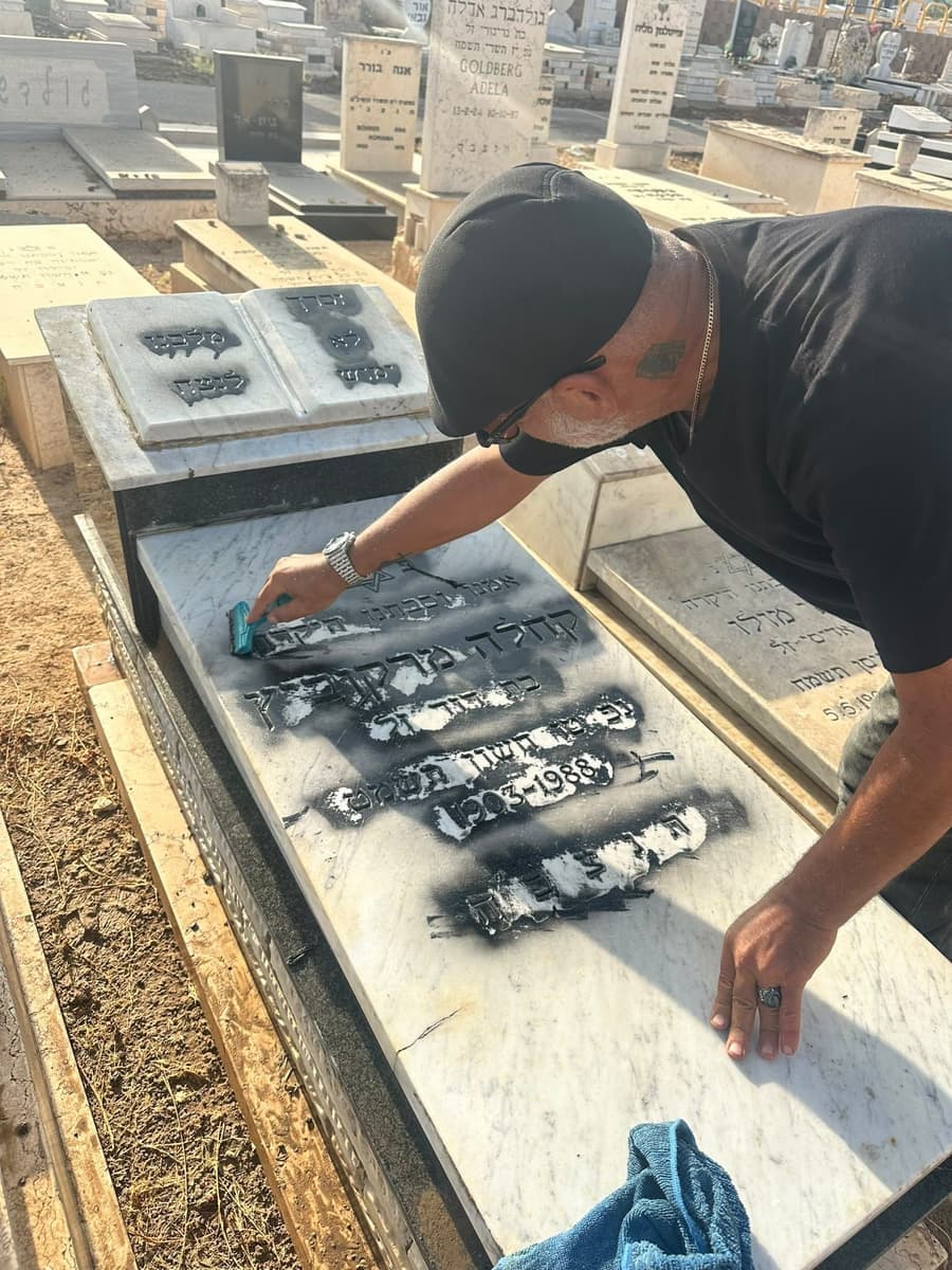 אלי גרבי מחדש וצובע את הכיתוב במצבת שיש