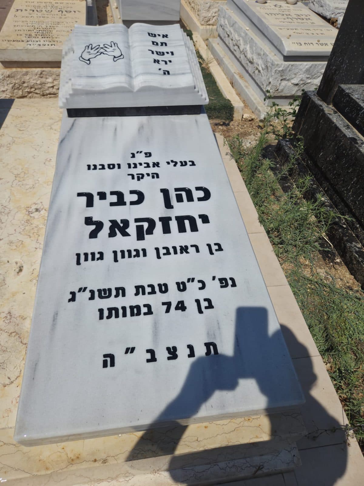 מצבה עם ספר פתוח וכיתוב מחודש